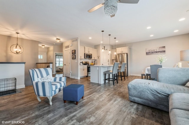 2401 E 50th St, Des Moines, IA 50317 - living area featuring a ceiling fan, recessed lighting, dark wood-type flooring, and a chandelier