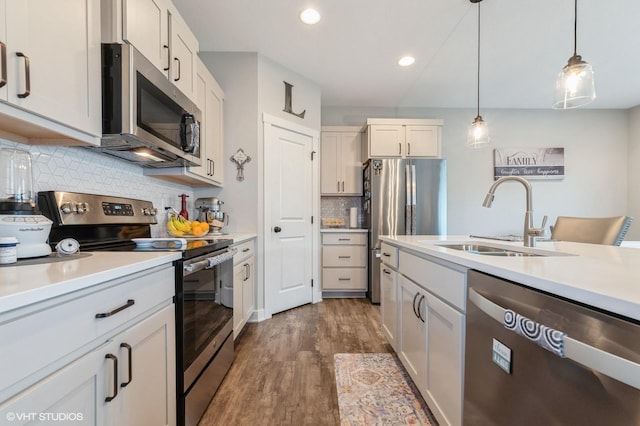 2401 E 50th St, Des Moines, IA 50317 - kitchen featuring stainless steel appliances, dark wood-style floors, light countertops, recessed lighting, and decorative backsplash
