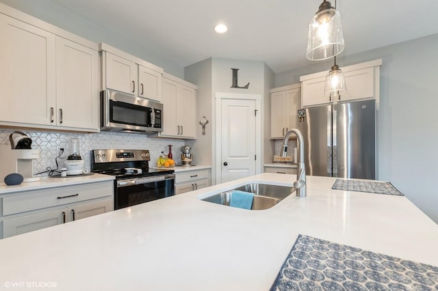 2401 E 50th St, Des Moines, IA 50317 - kitchen featuring stainless steel appliances, tasteful backsplash, hanging light fixtures, recessed lighting, and light countertops