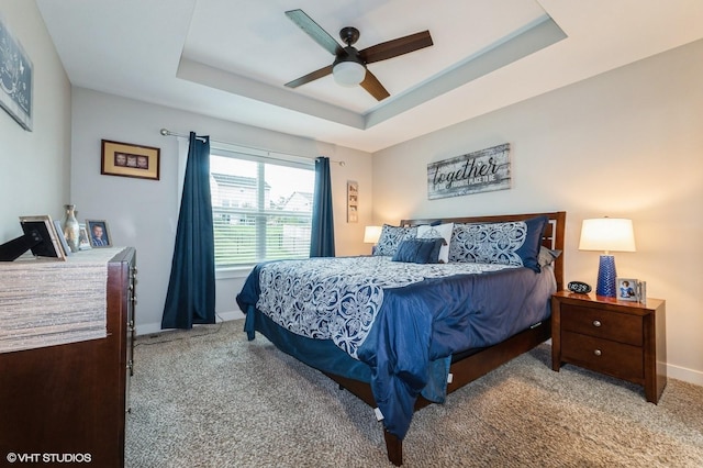 2401 E 50th St, Des Moines, IA 50317 - carpeted bedroom featuring a raised ceiling and a ceiling fan