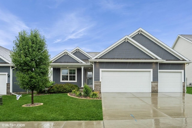 2401 E 50th St, Des Moines, IA 50317 - craftsman inspired home with an attached garage, concrete driveway, stone siding, and a front lawn
