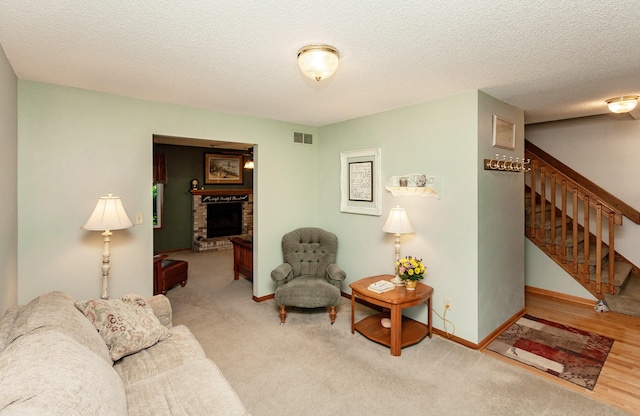3806 Columbine Ave, Ames, IA 50010 - carpeted living room with stairway, a brick fireplace, and a textured ceiling