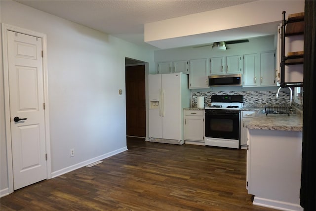 609 E Filmore St, Winterset, IA 50273 - kitchen with white appliances and dark wood finished floors
