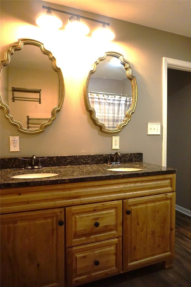 609 E Filmore St, Winterset, IA 50273 - bathroom featuring double vanity and wood finished floors
