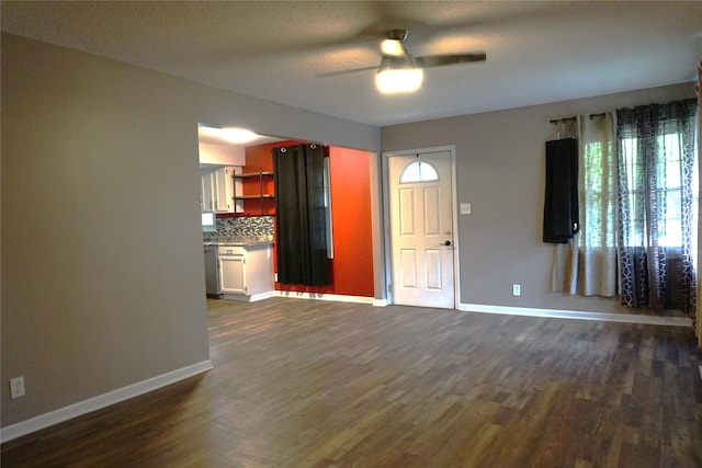609 E Filmore St, Winterset, IA 50273 - unfurnished living room featuring ceiling fan and dark wood-type flooring