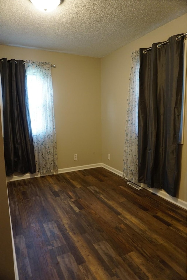 609 E Filmore St, Winterset, IA 50273 - spare room with dark wood-style floors and a textured ceiling