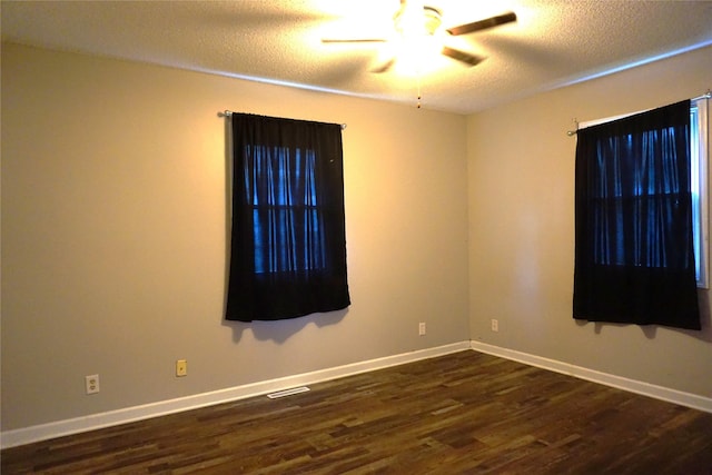 609 E Filmore St, Winterset, IA 50273 - empty room with dark wood-style floors, a textured ceiling, and a ceiling fan
