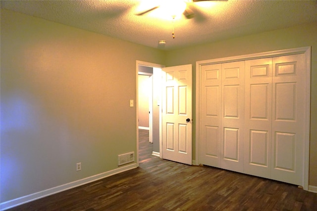 609 E Filmore St, Winterset, IA 50273 - unfurnished bedroom featuring dark wood-type flooring, a textured ceiling, a closet, and ceiling fan