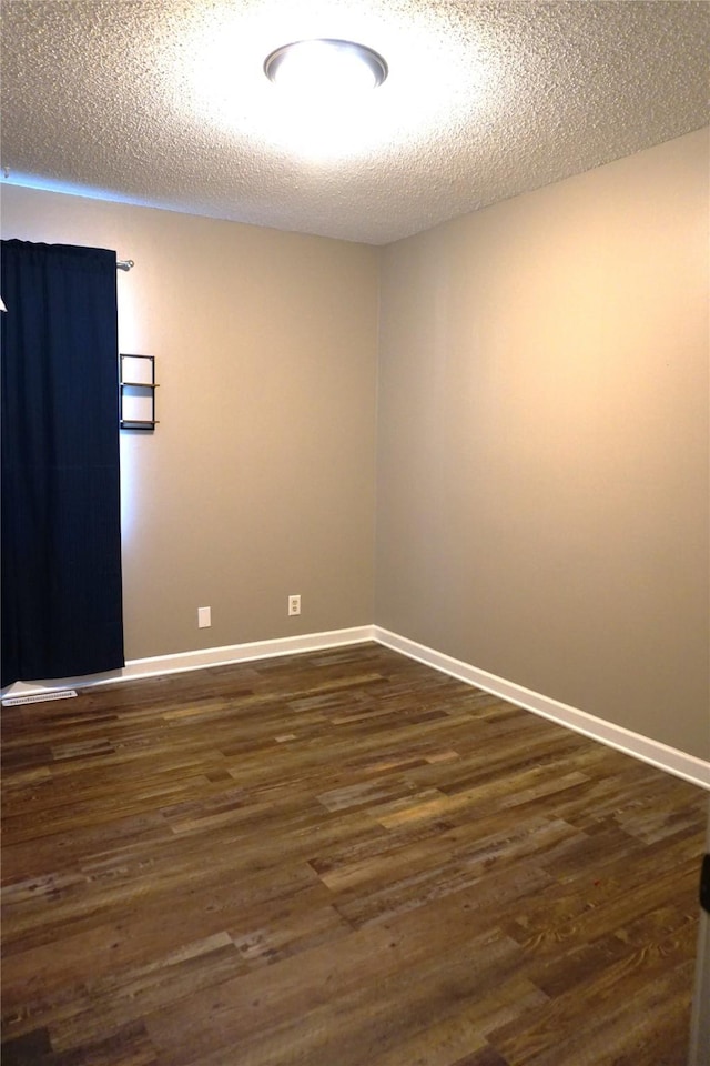 609 E Filmore St, Winterset, IA 50273 - spare room with dark wood-style flooring and a textured ceiling