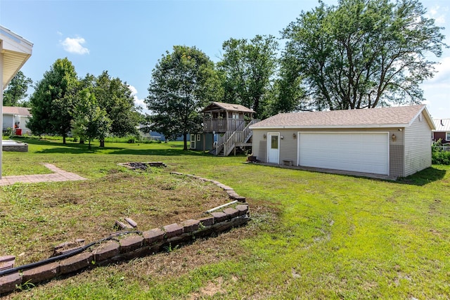 208 SW 4th St, Ogden, IA 50212 - view of green lawn with stairs, a detached garage, an outdoor structure, and a deck