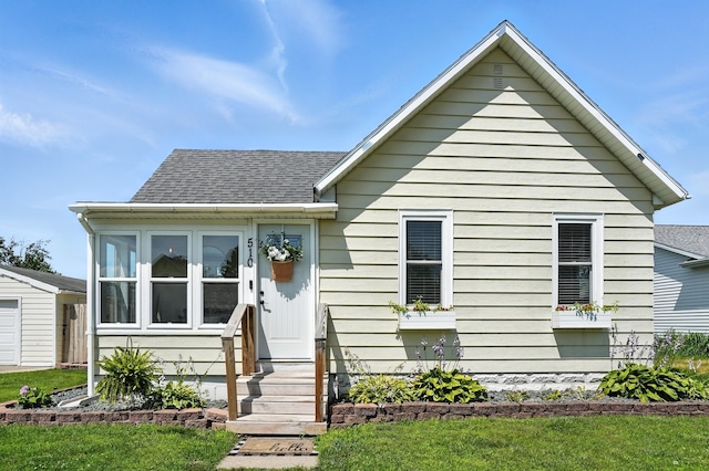 510 Maple Ave, Woodward, IA 50276 - bungalow-style home with roof with shingles, entry steps, and a front lawn