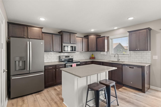 2718 NW 23rd St, Ankeny, IA 50023 - kitchen featuring appliances with stainless steel finishes, light wood-type flooring, dark brown cabinets, light countertops, and recessed lighting