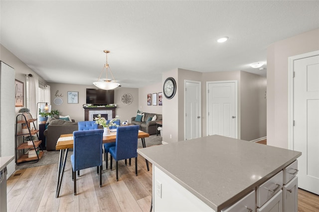 2718 NW 23rd St, Ankeny, IA 50023 - dining space featuring light wood-style flooring, recessed lighting, and a fireplace