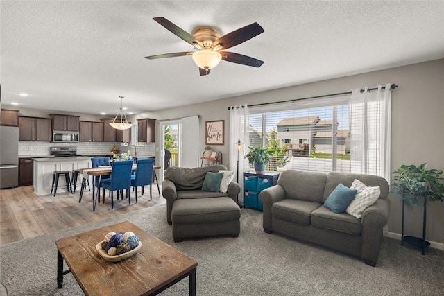 2718 NW 23rd St, Ankeny, IA 50023 - living area featuring a ceiling fan and a textured ceiling