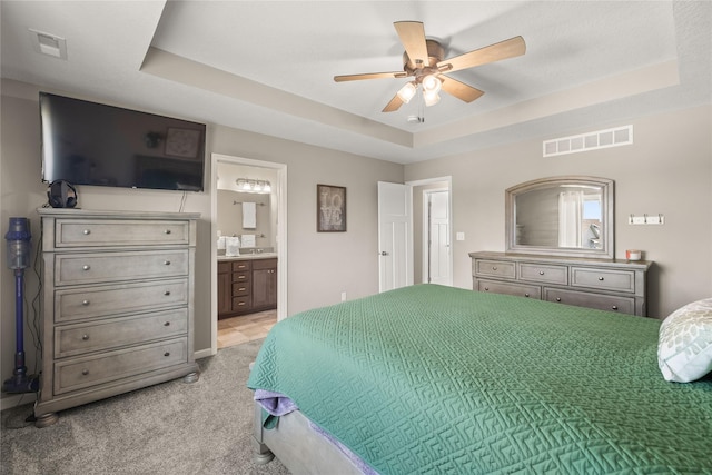2718 NW 23rd St, Ankeny, IA 50023 - bedroom with a raised ceiling, light carpet, ensuite bath, and ceiling fan