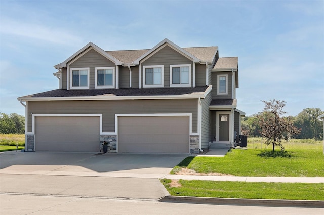 2017 NE Heritage Dr, Grimes, IA 50111 - view of front of house featuring a garage, a front yard, driveway, and stone siding