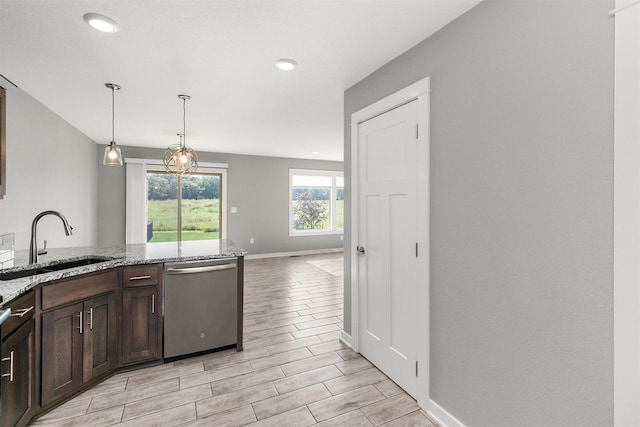 2017 NE Heritage Dr, Grimes, IA 50111 - kitchen featuring stainless steel dishwasher, dark brown cabinetry, light stone countertops, wood finish floors, and decorative light fixtures