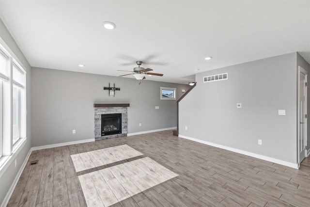 2017 NE Heritage Dr, Grimes, IA 50111 - unfurnished living room featuring a ceiling fan, wood finished floors, a stone fireplace, and recessed lighting