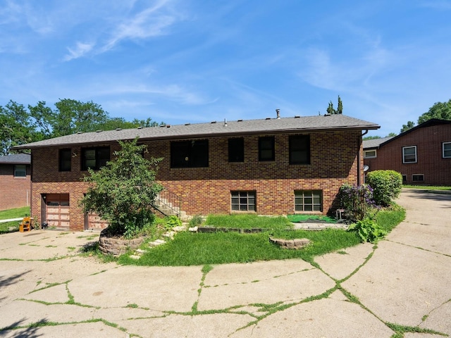 1509 Del Matro Ct, Windsor Heights, IA 50324 - view of front of property featuring brick siding, driveway, a garage, and stairs