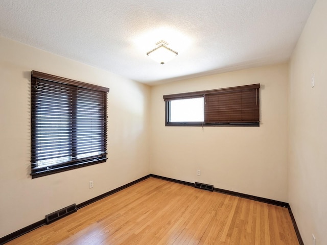 1509 Del Matro Ct, Windsor Heights, IA 50324 - spare room featuring light wood-type flooring and a textured ceiling