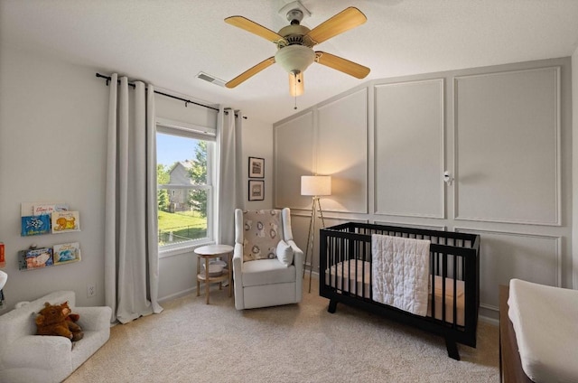 145 SE Kellerman Ln, Waukee, IA 50263 - bedroom with a nursery area, light carpet, and a ceiling fan