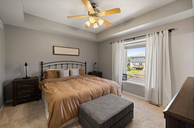 145 SE Kellerman Ln, Waukee, IA 50263 - bedroom featuring light carpet, a raised ceiling, and a ceiling fan