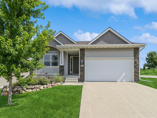 8955 Jamison Dr, West Des Moines, IA 50266 - view of front of house featuring stone siding, a front lawn, driveway, and an attached garage