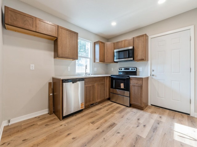 404 S B St, Indianola, IA 50125 - kitchen featuring stainless steel appliances, light wood-type flooring, recessed lighting, light countertops, and brown cabinetry