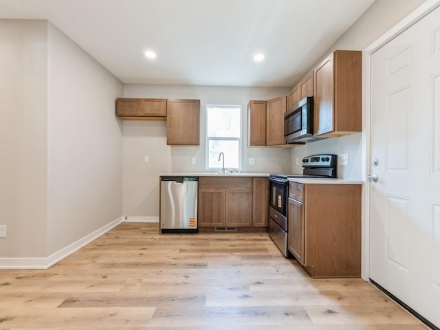 404 S B St, Indianola, IA 50125 - kitchen with appliances with stainless steel finishes, light wood finished floors, brown cabinets, light countertops, and recessed lighting