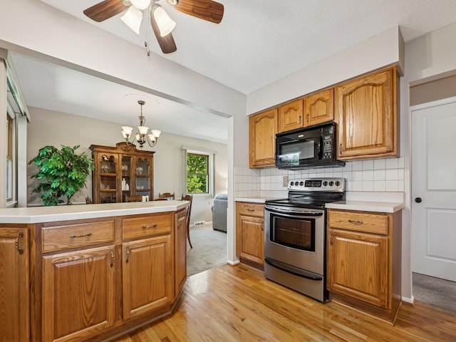 4408 66th St, Urbandale, IA 50322 - kitchen with stainless steel electric range oven, black microwave, light wood-style floors, and light countertops