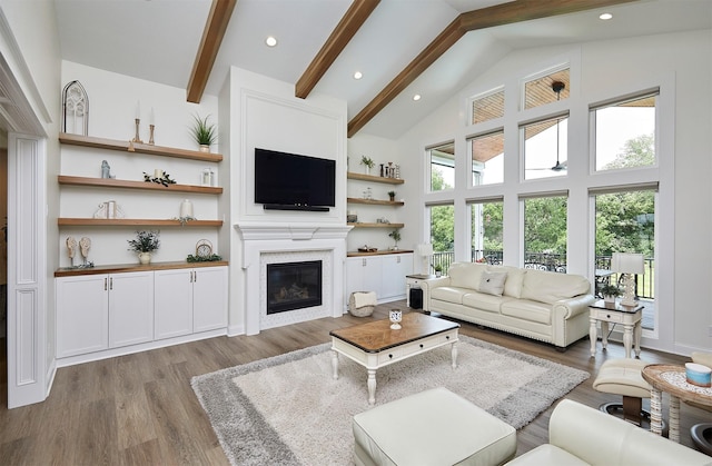 11174 NW 108th Ct, Granger, IA 50109 - living area featuring healthy amount of natural light, beam ceiling, wood finished floors, a glass covered fireplace, and high vaulted ceiling