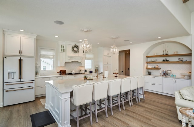 11174 NW 108th Ct, Granger, IA 50109 - kitchen with high end fridge, decorative backsplash, white cabinets, a chandelier, and recessed lighting