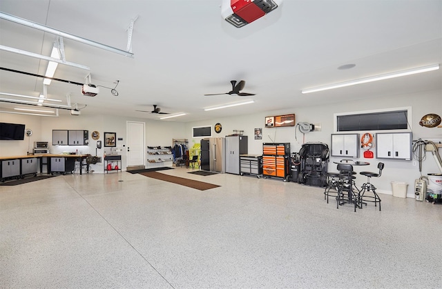 11174 NW 108th Ct, Granger, IA 50109 - garage featuring a garage door opener, ceiling fan, and a workshop area