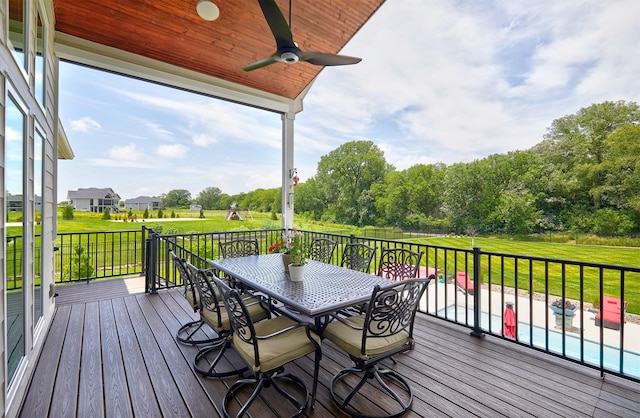 11174 NW 108th Ct, Granger, IA 50109 - wooden terrace with ceiling fan, outdoor dining space, a yard, and view of wooded area