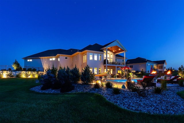 11174 NW 108th Ct, Granger, IA 50109 - back of house at twilight featuring a balcony, a lawn, and a patio area