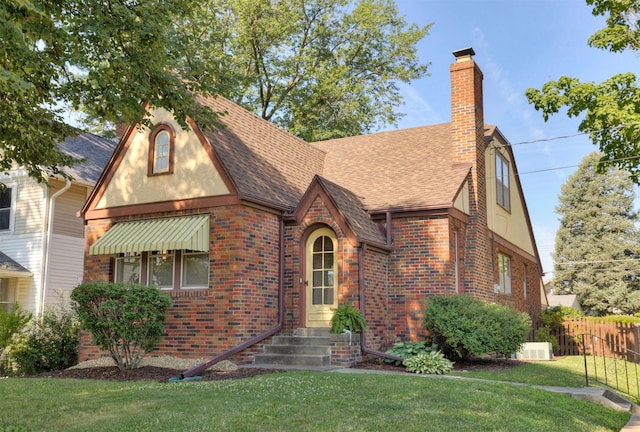 2220 York St, Des Moines, IA 50316 - english style home featuring roof with shingles, brick siding, a chimney, and stucco siding