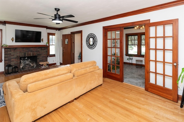 2220 York St, Des Moines, IA 50316 - living room featuring wood finished floors, crown molding, a ceiling fan, and a fireplace
