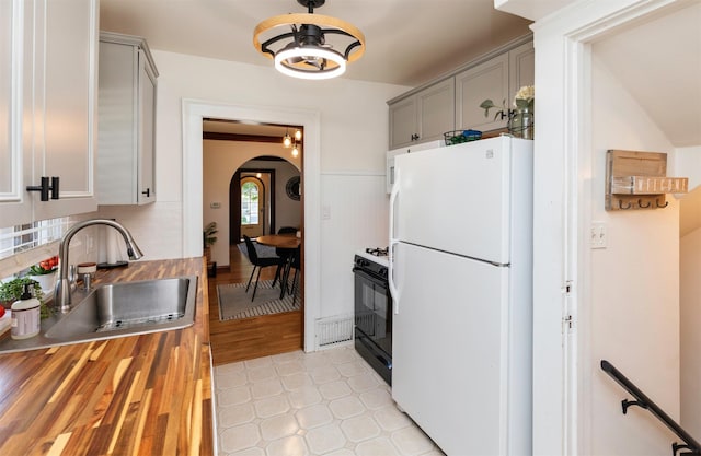 2220 York St, Des Moines, IA 50316 - kitchen with freestanding refrigerator, butcher block countertops, gray cabinetry, arched walkways, and wainscoting
