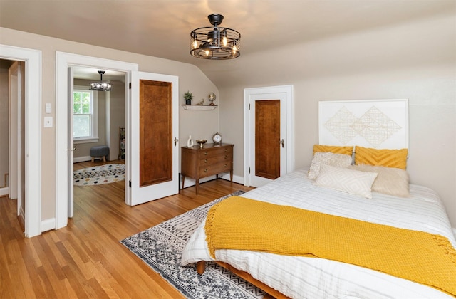 2220 York St, Des Moines, IA 50316 - bedroom featuring a chandelier, light wood-style flooring, and lofted ceiling