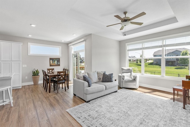 2845 SE Bluestem Dr, Waukee, IA 50263 - living area featuring light wood-style floors, a raised ceiling, recessed lighting, and a ceiling fan