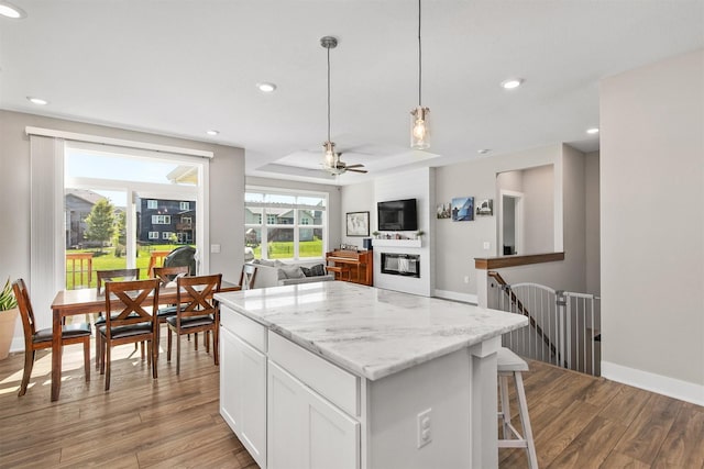 2845 SE Bluestem Dr, Waukee, IA 50263 - kitchen featuring wood finished floors, white cabinetry, recessed lighting, a center island, and ceiling fan