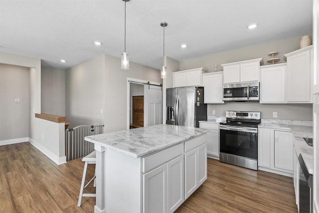 2845 SE Bluestem Dr, Waukee, IA 50263 - kitchen featuring appliances with stainless steel finishes, a barn door, a center island, white cabinetry, and dark wood-type flooring