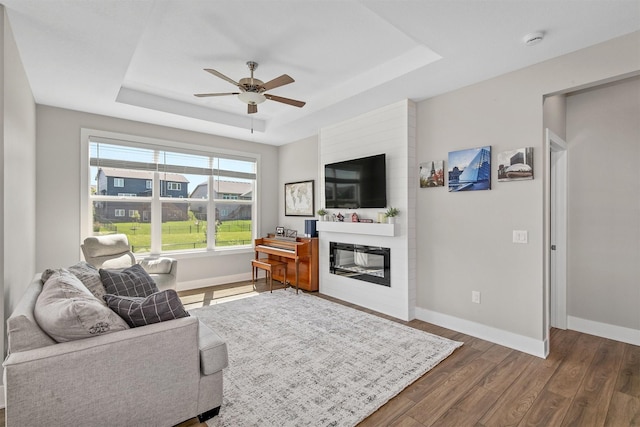 2845 SE Bluestem Dr, Waukee, IA 50263 - living room with a raised ceiling, dark wood-style flooring, ceiling fan, and a fireplace