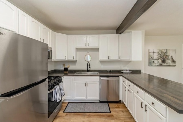 3901 Lawnwoods Dr, Des Moines, IA 50310 - kitchen with appliances with stainless steel finishes, a peninsula, beamed ceiling, and dark countertops
