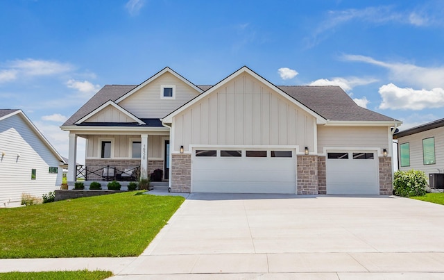 16320 Northpark Dr, Urbandale, IA 50323 - craftsman-style home featuring board and batten siding, an attached garage, stone siding, a porch, and a front lawn