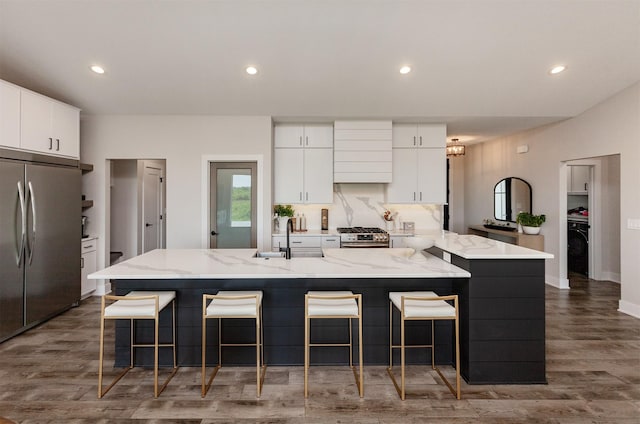 16320 Northpark Dr, Urbandale, IA 50323 - kitchen featuring stainless steel appliances, white cabinets, a kitchen bar, a large island with sink, and recessed lighting