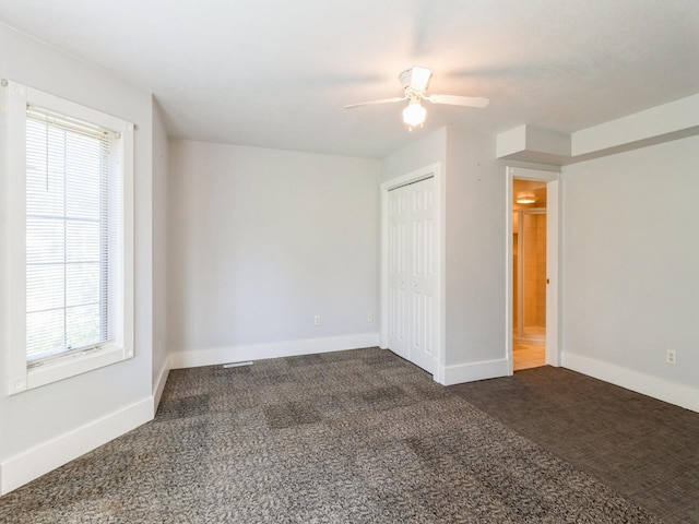 780 Iowa Ave, Martensdale, IA 50160 - unfurnished bedroom with dark colored carpet, a closet, and ceiling fan