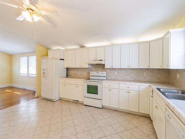 780 Iowa Ave, Martensdale, IA 50160 - kitchen featuring white appliances, under cabinet range hood, decorative backsplash, and tile countertops