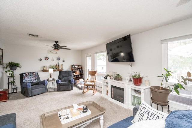 729 SE 3rd St, Ankeny, IA 50021 - living area with carpet flooring, a ceiling fan, and a glass covered fireplace