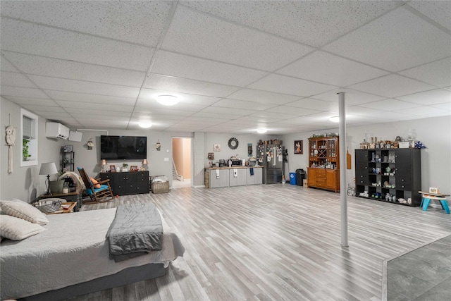 729 SE 3rd St, Ankeny, IA 50021 - bedroom with freestanding refrigerator, wood finished floors, a drop ceiling, and a wall mounted AC